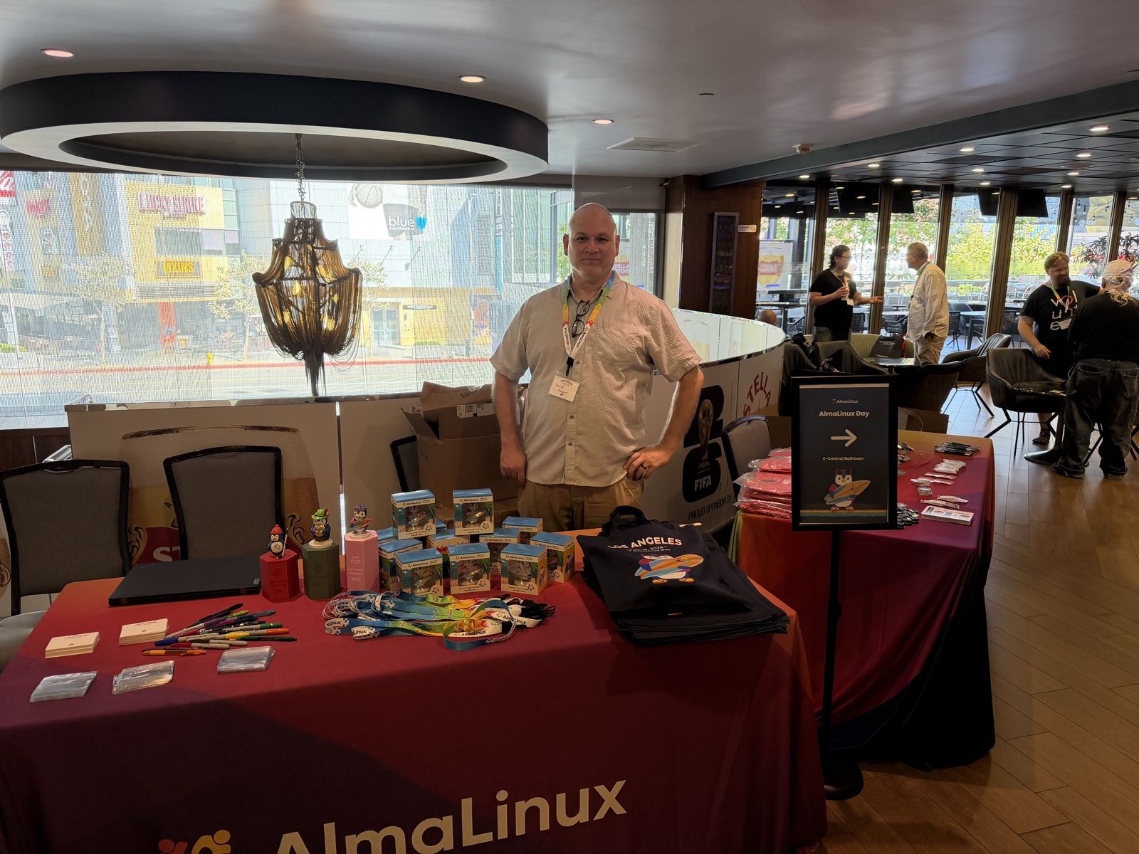 David Duncan standing behind a table of AlmaLinux swag